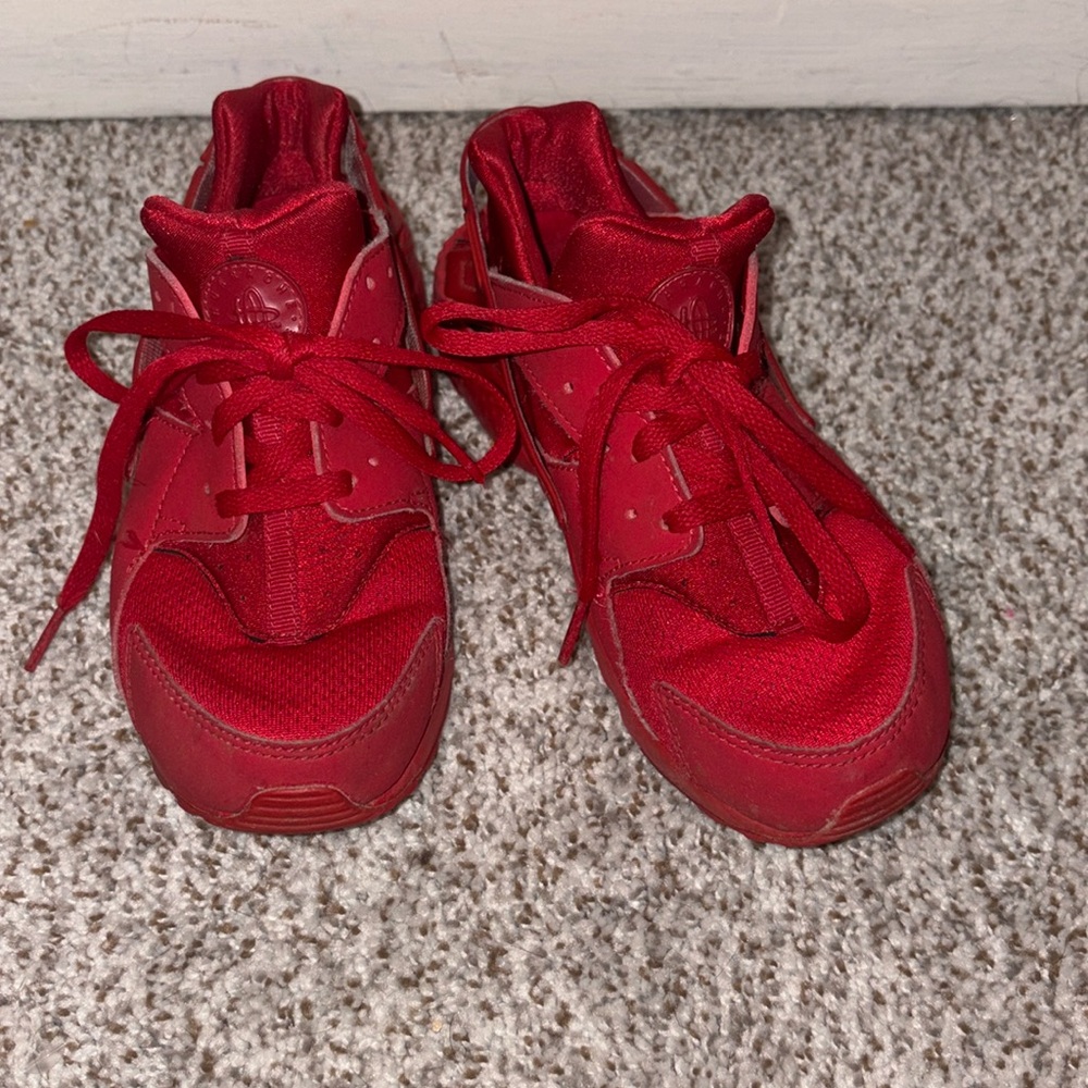 Young boys red Nike sneakers used.